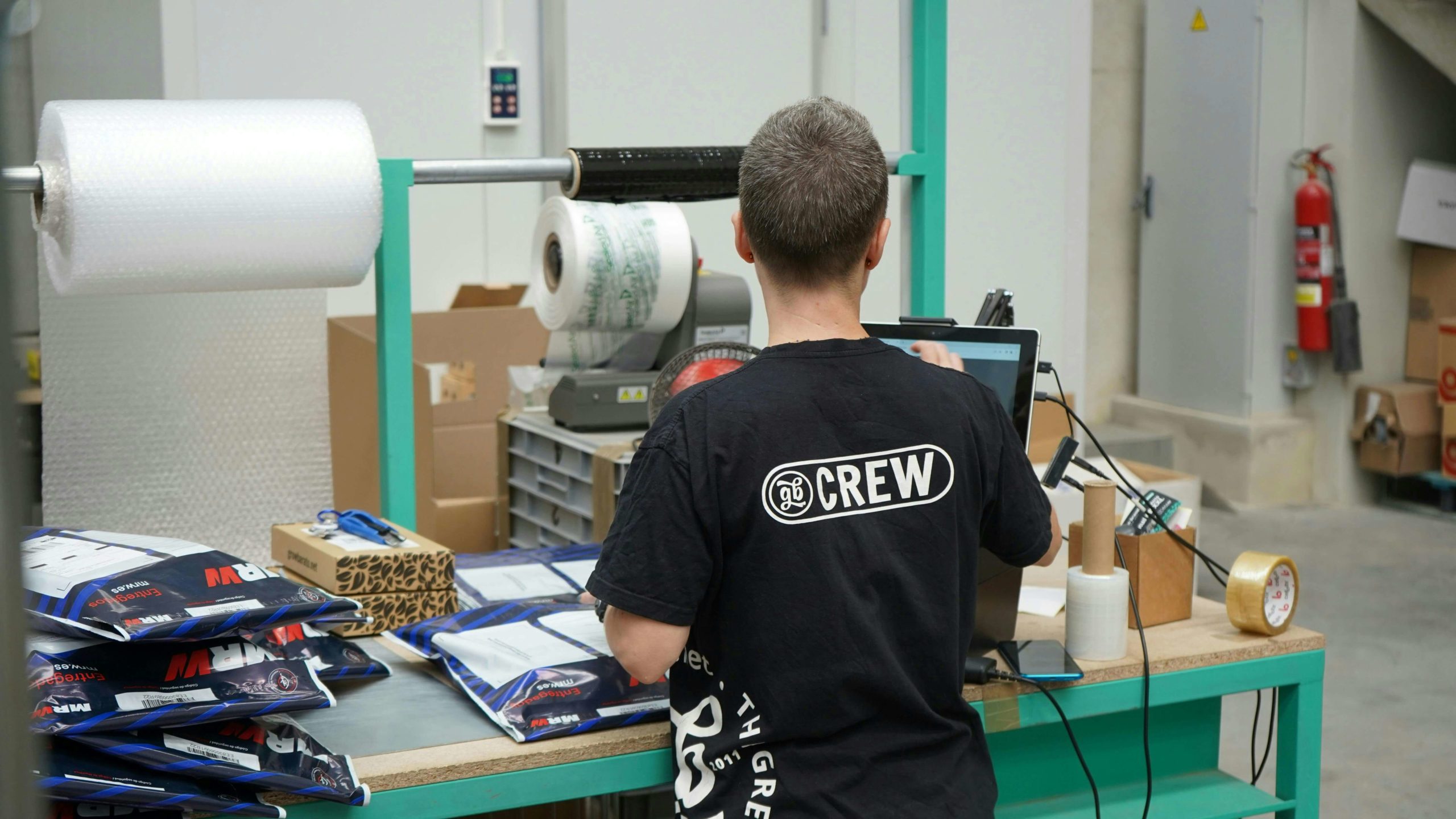 Warehouse packing station with operations staff handling B2B and wholesale orders