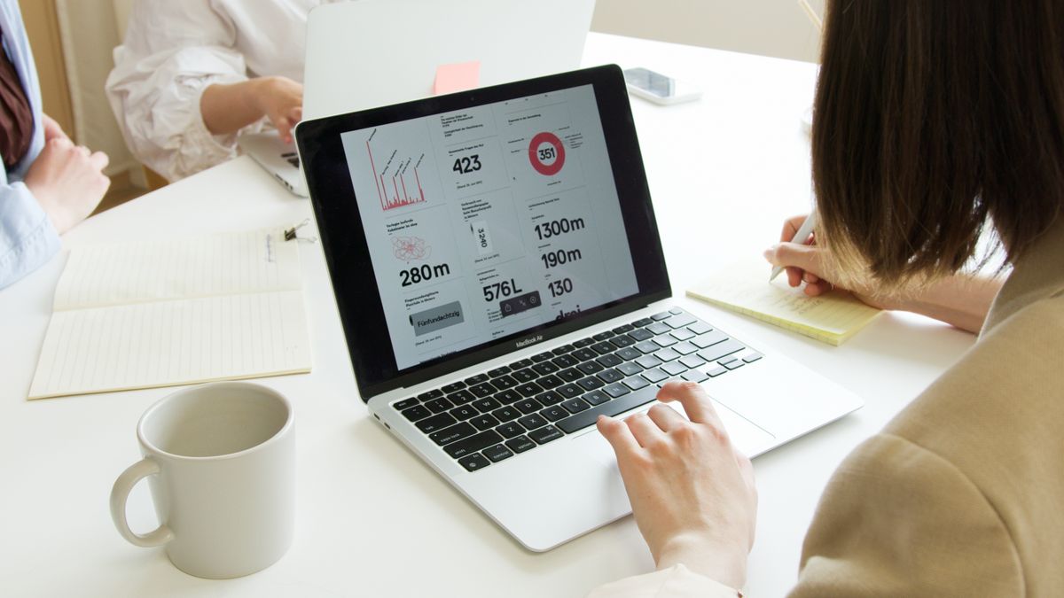 Two people reviewing an analytics dashboard on a laptop while planning a store migration