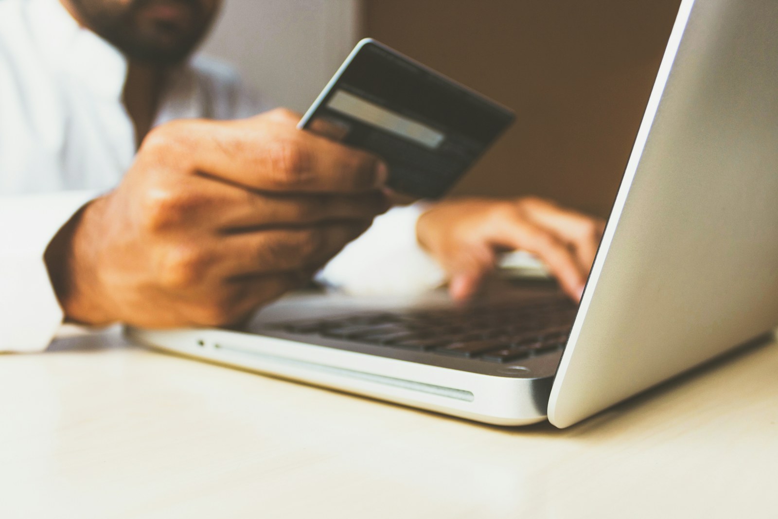 Shopper entering a credit card while completing an online order on a laptop
