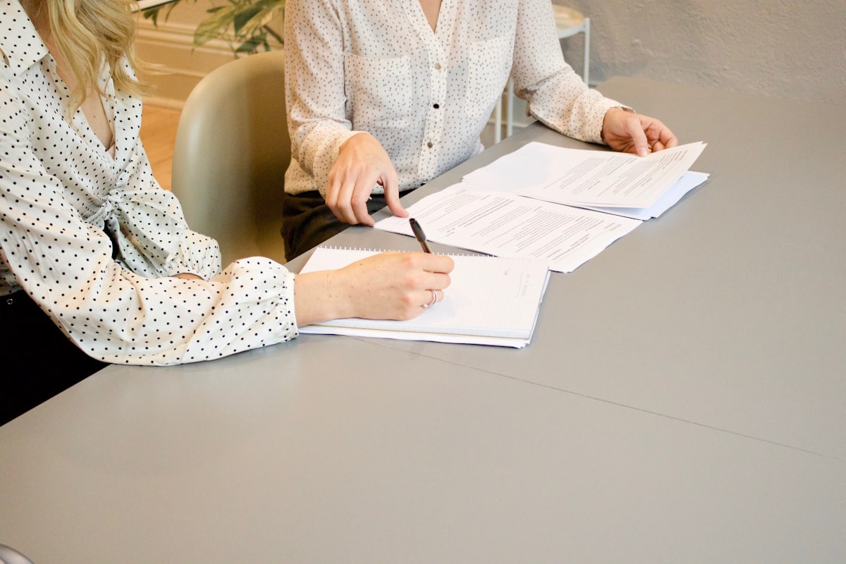 Two people reviewing paperwork while comparing ecommerce platforms